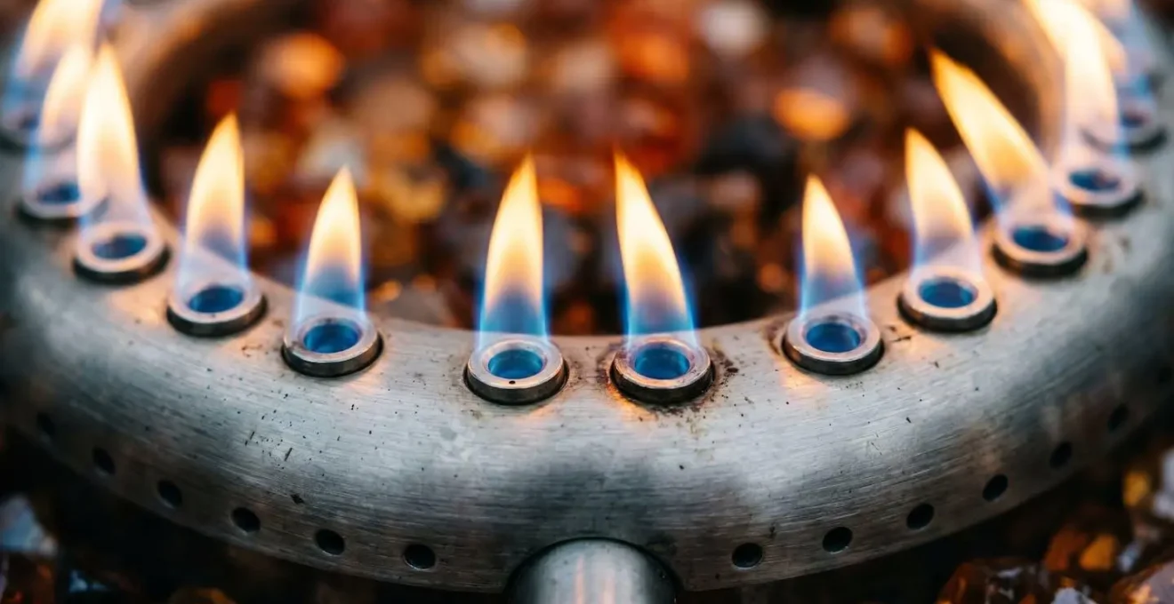 Macro close-up of gas fire table burner jets showing proper blue flame pattern with detailed texture