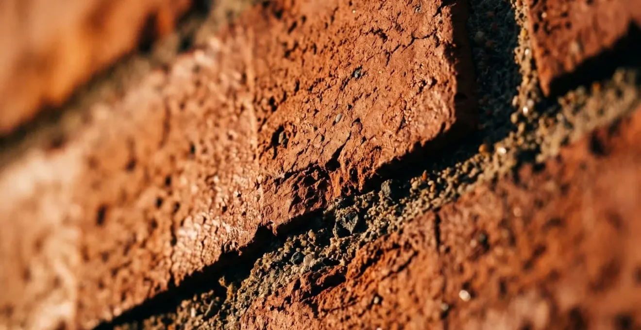 Macro detail of brick texture illuminated by grazing light showing deep shadows in mortar joints