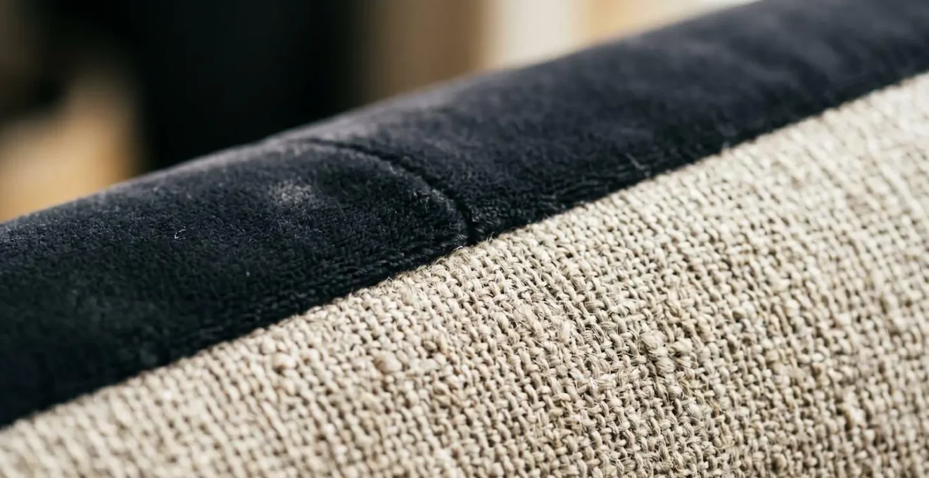 Macro detail of luxurious velvet cushion texture contrasting with natural wrinkled linen sofa fabric in soft natural light